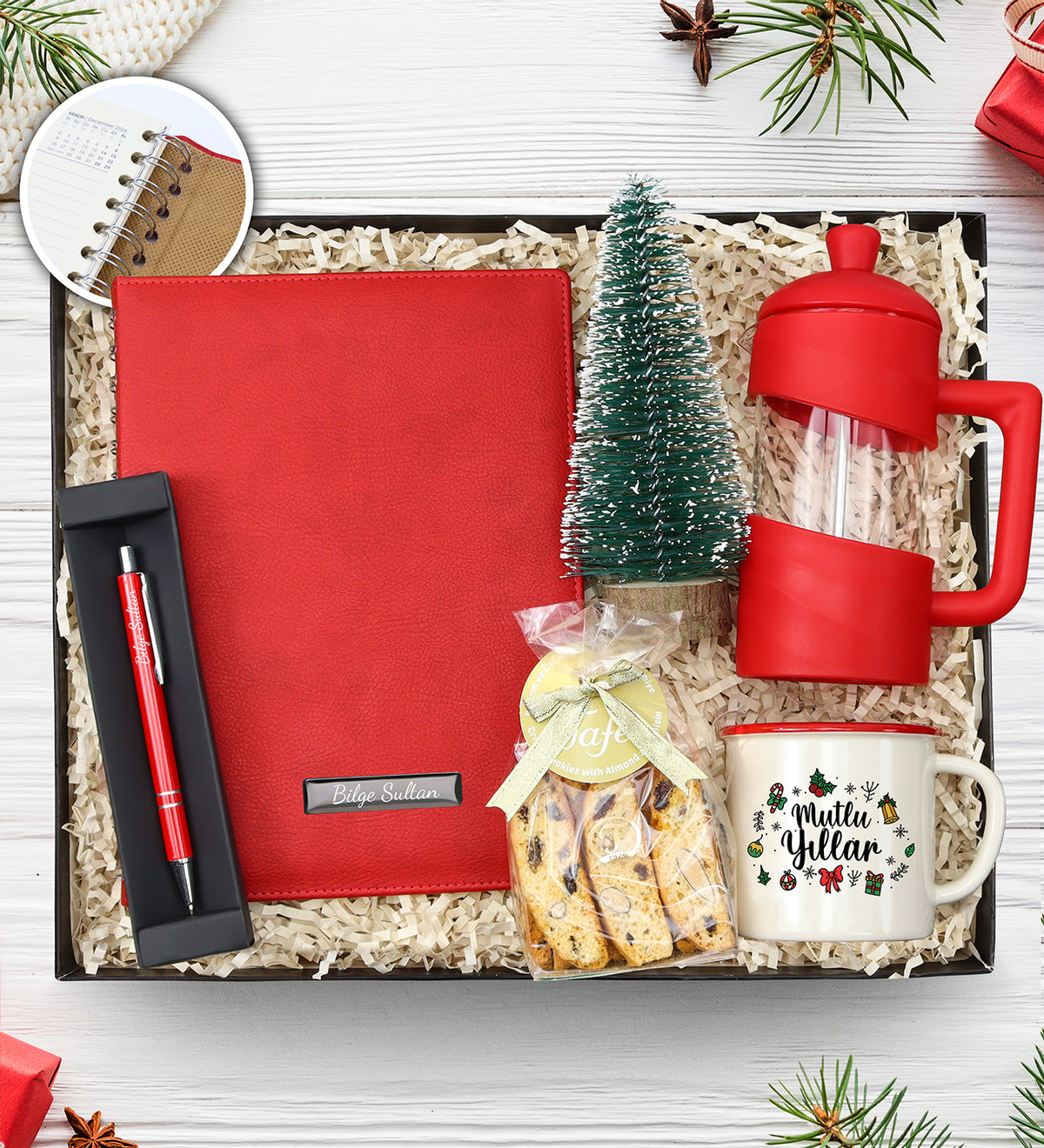Kişiye Özel Kırmızı Spiralli 2026 Yeni Yıl Tarihli Ajanda & Gümüş Renk Detaylı Kırmızı Tükenmez Kalem & Ahşap Zeminli Mini Çam Ağacı & Mutlu Yıllar Temalı Vintage Kupa & Bademli Kurabiye & Kırmızı French Press Hediye Seti