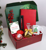 Yılbaşı Kutusunda Kırmızı Spiralli Yeni Yıl Tarihli Ajanda & Gümüş Renk Detaylı Kırmızı Tükenmez Kalem & Yılbaşı Kupa & Yılbaşı Temalı Metal Kutulu Mum & Godiva Napoliten Çikolata Hediye Seti