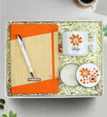 Kişiye Özel Turuncu Tasarım Defter & T Kupa & Gümüş Renk Detaylı Beyaz Tükenmez Kalem &Çiçekli Beyaz Metal Kutulu Mum Hediye Seti