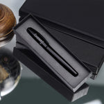 Yılbaşı Kutusunda Kişiye Özel Siyah Spiralli Yeni Yıl Tarihli Ajanda & Siyah Mat Tükenmez Kalem & 125gr Selamlıque Türk Kahvesi & Siyah Seramik Fincan & Godiva Napoliten Çikolata & Ahşap Zeminli Mini Çam Ağacı Hediye Seti